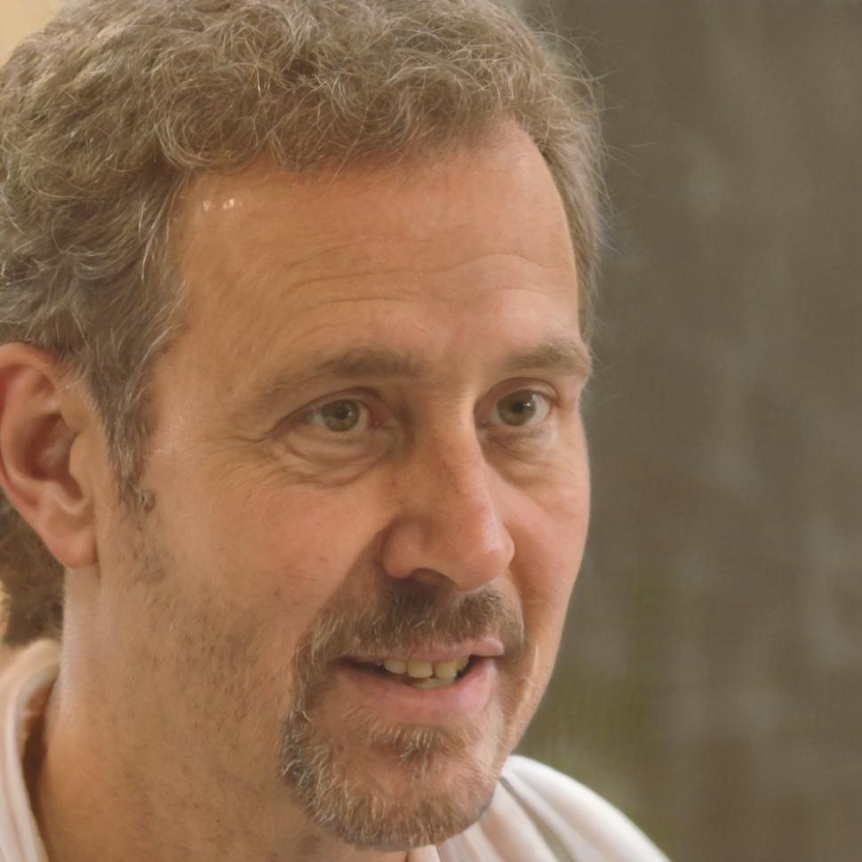 Instructional designer reviewing blockchain training materials at desk with multiple screens showing course content and documentation